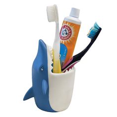 toothbrushes, toothpaste and toothpaste in a cup shaped like a dolphin