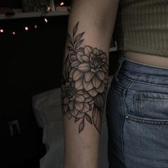 a woman's arm with a flower tattoo on the left side of her arm