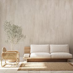 a white couch sitting next to a table on top of a wooden floor in front of a wall