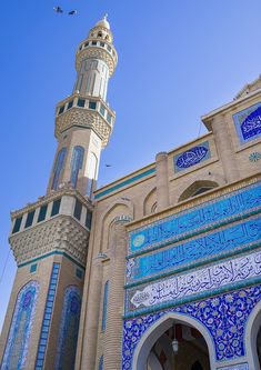 an ornate building with blue and white tiles on it's sides, against a clear blue sky