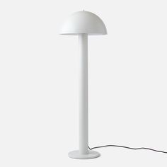 a white table lamp with a cord attached to it