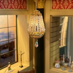 a chandelier hanging from the ceiling in front of a window