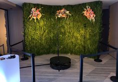 an artificial green wall with flowers on it