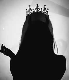 the silhouette of a woman with a crown on her head is shown in black and white