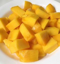 a white plate topped with cut up mangoes