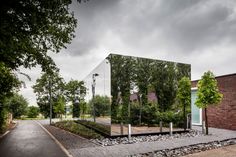 a mirrored building with trees in the background