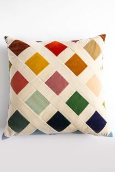 a multicolored pillow sitting on top of a white wall