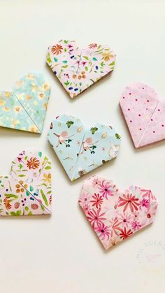 paper hearts laid out on top of each other in different colors and patterns, with one heart cut into smaller pieces