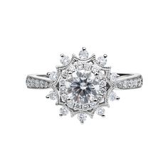 a white gold ring with diamonds on the sides and an intricate halo style design in the center