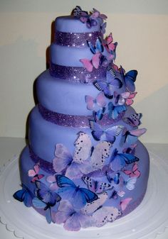 a three tiered purple cake with butterflies on it