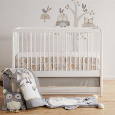 a white crib with an owl decal on the wall