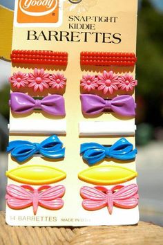 a package of hair clips with flowers and bows on top of each one in front of an advertisement for goody