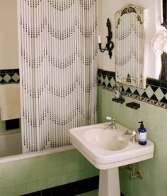 a white sink sitting under a bathroom mirror next to a bath tub and shower curtain