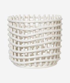 a white basket that is sitting on the ground with no handles and two rows of woven material