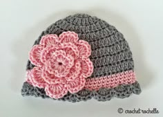 a crocheted hat with a pink flower on the front and gray brim