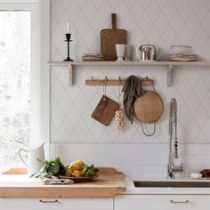 a kitchen counter with utensils hanging on the wall