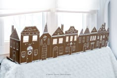 there is a cardboard cutout of houses on the window sill in front of the windowsill