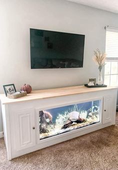 a flat screen tv mounted to the side of a white cabinet in a living room