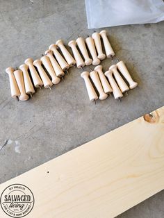 several wooden pegs are laying on the floor next to a piece of wood