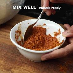 a person scooping out some food into a white bowl on a wooden table with the words mix well - masala ready