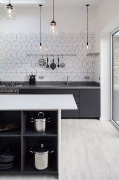 a kitchen with black cabinets and white counter tops