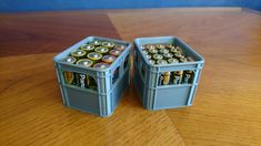 two plastic containers filled with batteries on top of a wooden table