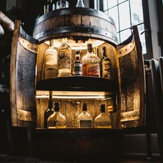 an open wooden barrel filled with liquor bottles