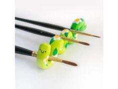 four chopsticks with green and white designs on them sitting next to each other