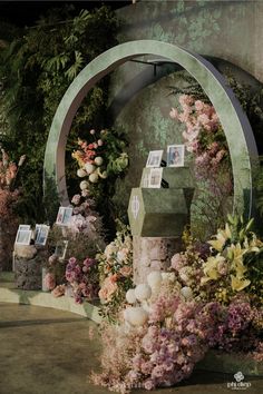 a bunch of flowers that are in front of a wall with pictures on the side