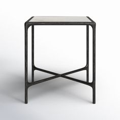 an iron and glass side table on a white background