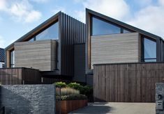 a modern house with large windows and wooden sidings on the side of the building