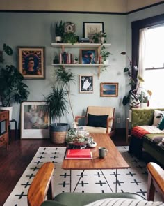 a living room filled with furniture and lots of plants on top of the shelves above