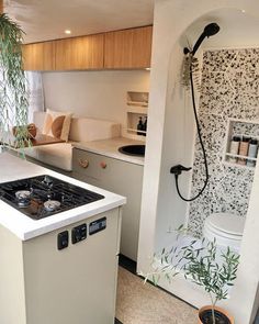 a kitchen with a stove top oven sitting next to a toilet and sink in it