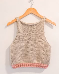 a knitted top hanging on a wooden hanger