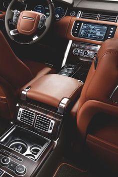 the interior of a car with brown leather seats and steering wheel, center console and dashboard controls