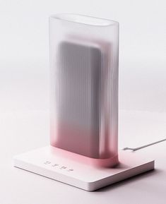 a white and pink object sitting on top of a table next to a charger