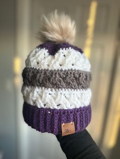 This super comfy beanie is exactly what you need this winter! The hats are crocheted and made with 100% acrylic yarn.  The purple, white, and gray hat fits a large child/small adult head. It is 7.5" tall when laid out, 10" with the pom pom included. It is also stretchy. The pom pom is faux fur. This hat was created based on the pattern found at this link: https://www.crochetforyoublog.com/2023/09/crochet-celtic-stripes-beanie/. Please contact me with any questions! White Acrylic Beanie One Size, Winter White Crochet Hat In Acrylic, White Acrylic Crochet Hat For Winter, White Acrylic Yarn Beanie For Winter, White Acrylic Crochet Hat Casual Style, Cozy White Crochet Hat, Casual White Crochet Acrylic Hat, Warm Cozy White Crochet Hat, Cozy Warm White Crochet Hat