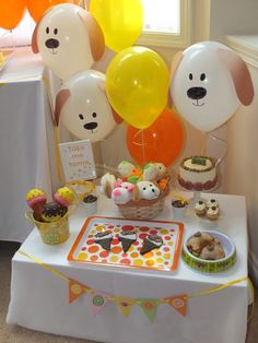 a table topped with lots of balloons and cakes