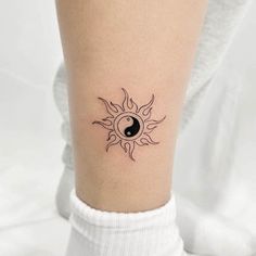 a woman's leg with a tattoo on it and the sun in the middle