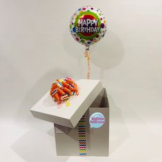 a happy birthday balloon sitting on top of a table