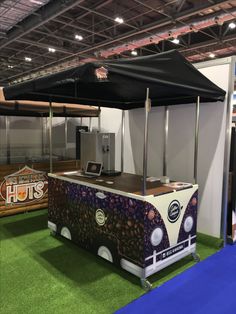 an ice cream truck is on display in a showroom with grass and blue carpet