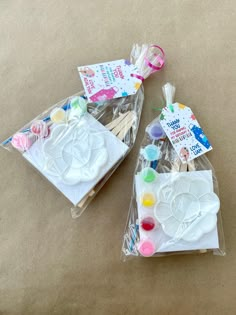 two plastic bags filled with craft supplies on top of a table