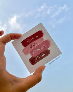 someone holding up a piece of paper with some writing on it in front of a blue sky