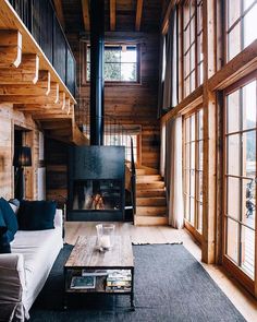 a living room filled with furniture and a fire place in the middle of a room