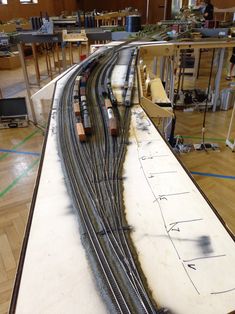 a model train track is being built on the table in front of some other tracks