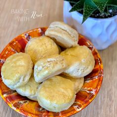 some biscuits are sitting on a plate next to a potted succulent plant