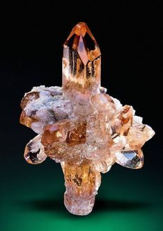 an orange and white crystal cluster on a green background