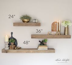 two wooden shelves with plants and candles on them