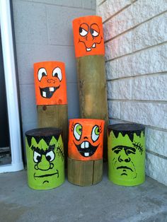 painted wooden logs with faces on them sitting in front of a door way and window