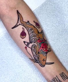 a tattoo on the arm of a woman with a fish and flowers in it's mouth